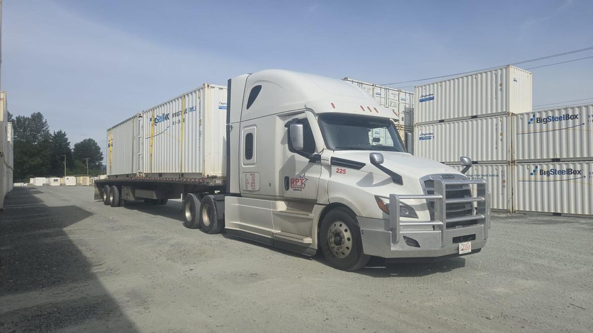 Right Path Trucking tractor hauling shipping containers on a flatbed trailer at a container yard