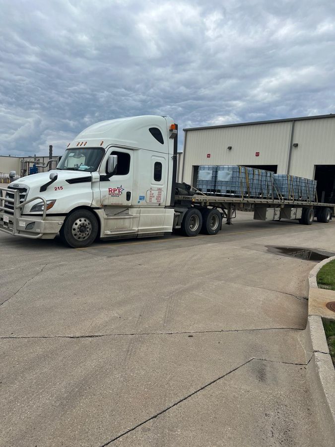 Right Path Trucking flatbed loaded and staged outside a warehouse