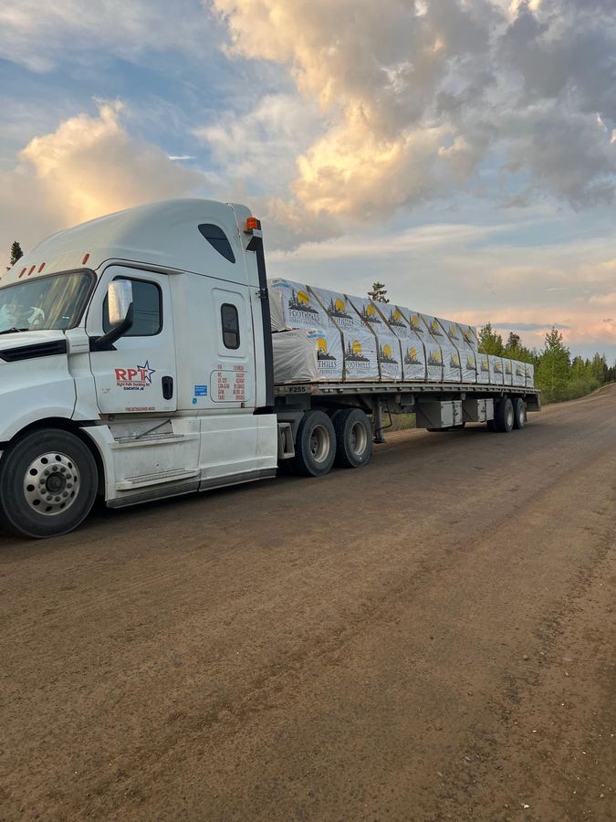 Right Path Trucking flatbed unit with a tarped load at dusk before a cross-border run