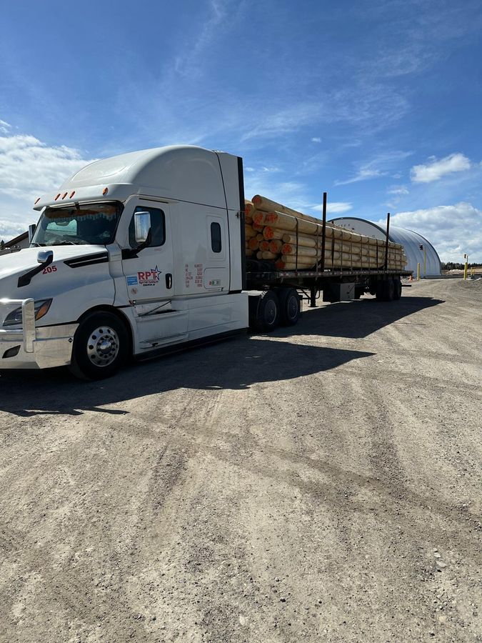 Banded lumber loaded on a Right Path Trucking flatbed trailer for delivery
